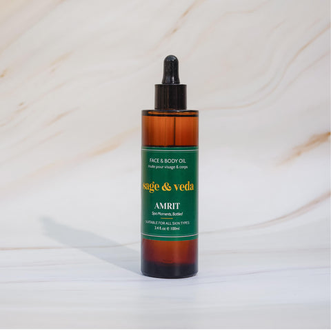 Sage & Veda Amrit oil 100ml bottle against neutral marble background.